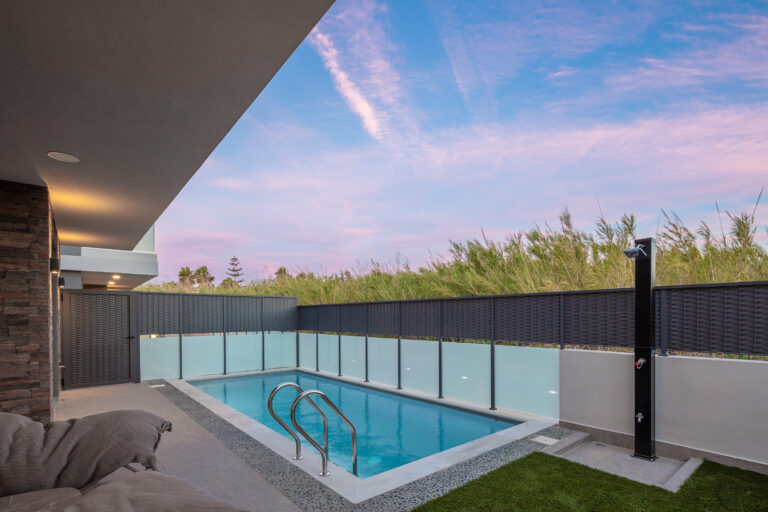 Private pool with modern fencing and sunset sky at VillaSaints Villas Chania