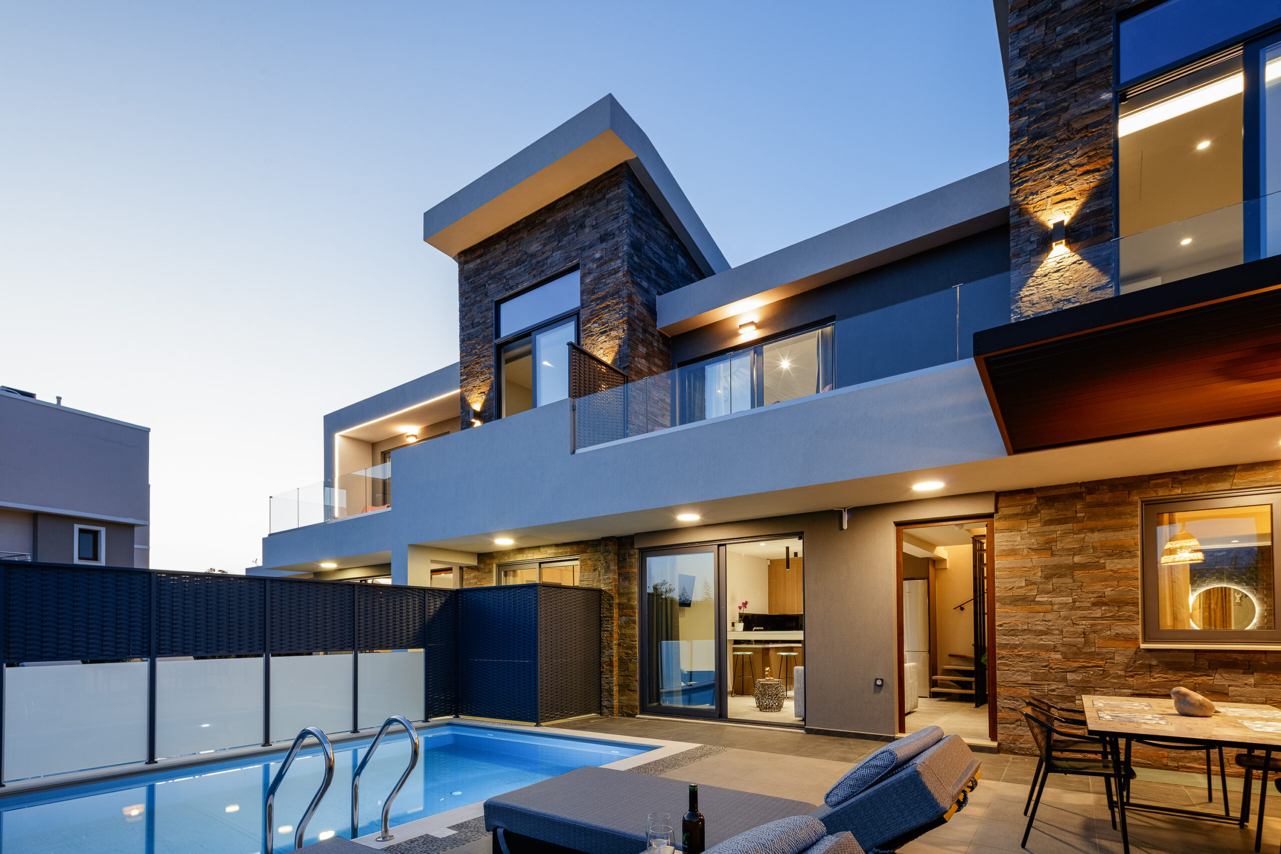 Evening view of villa exterior with illuminated pool at VillAgioi Villas Chania